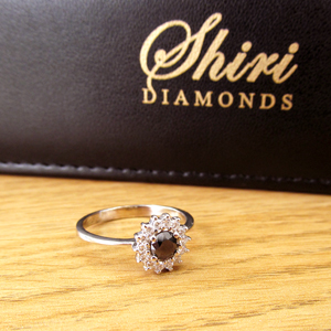 תמונה אמיתית של טבעת יהלומים בסגנון דיאנה משובצת יהלום שחור ויהלומים לבנים מסביב