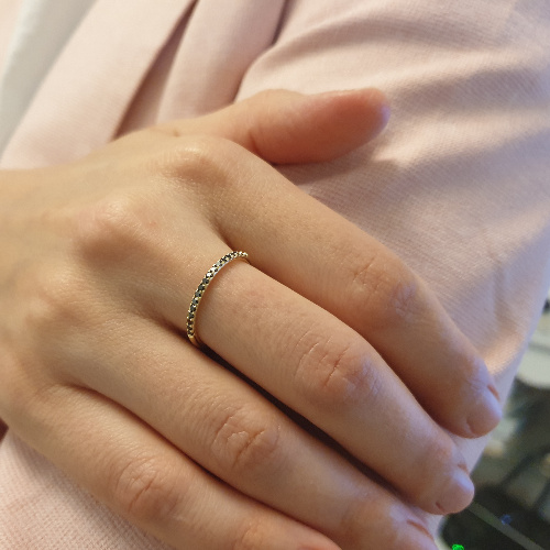 תמונה אמיתית של טבעת זהב משובצת שורה של יהלומים שחורים