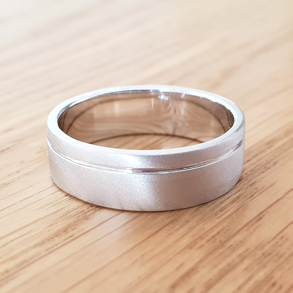 תמונה אמיתית של טבעת נישואין לגבר עם חריטת פס בצד
